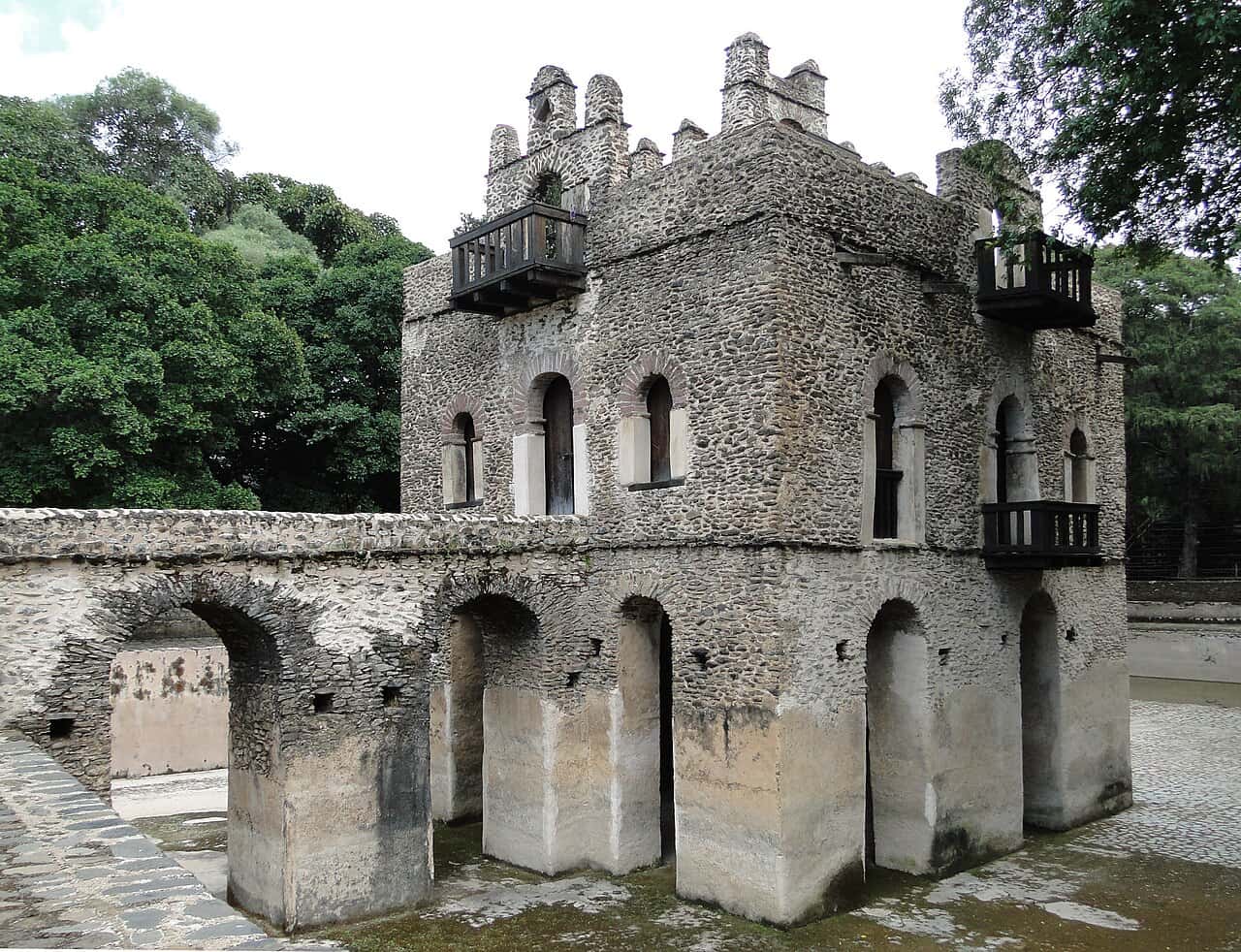 The stone pavilion of Fasilides' Bath standing on arches above its empty pool, Gondar