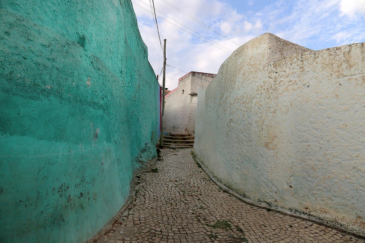 Narrow cobbled lane in Harar's old town between green and whitewashed walls