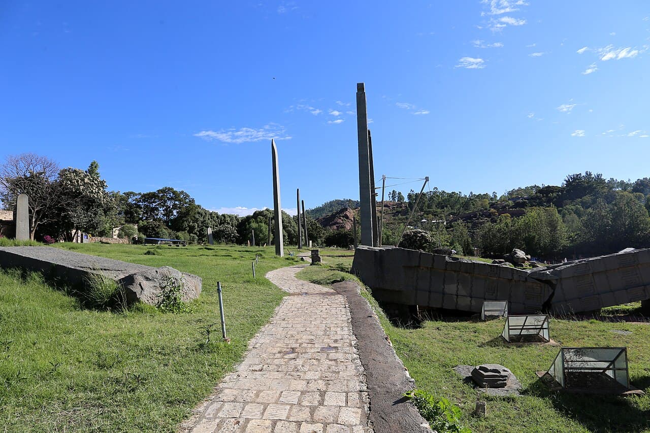Stone path through the Northern Stelae Park in Aksum, with tall stelae and the fallen Great Stele