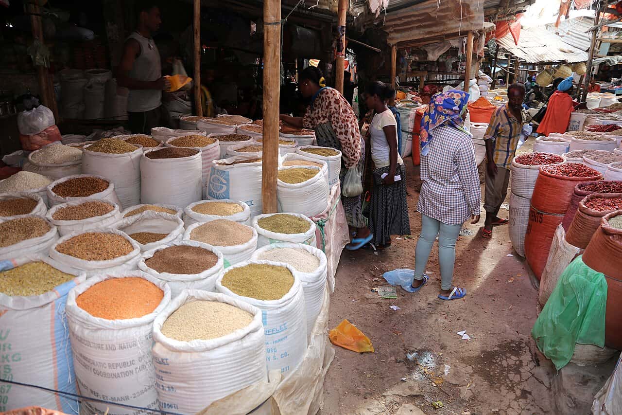Open sacks of grain, pulses and spices at a busy market in Harar
