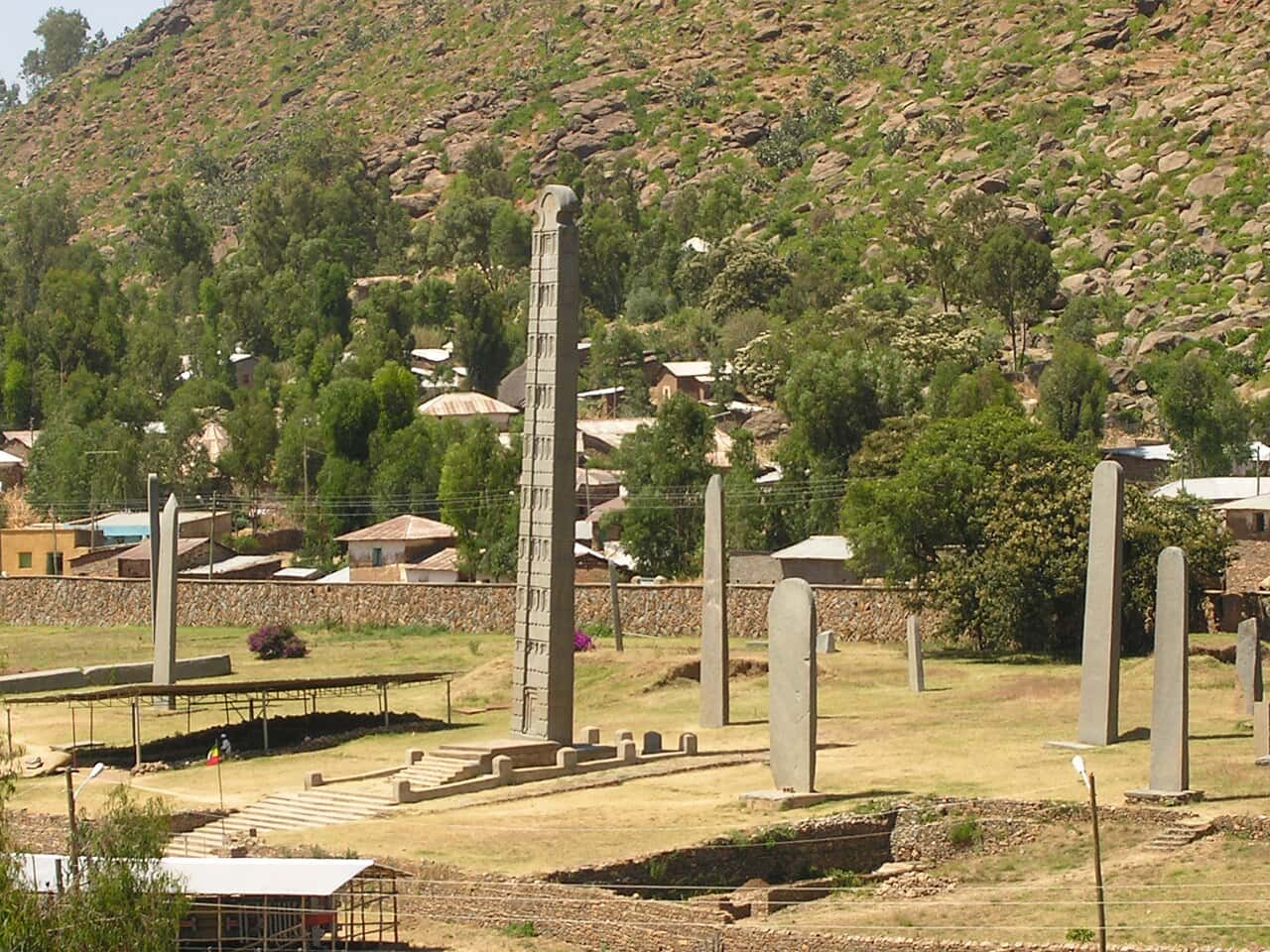 The stelae field in Aksum with the town and a rocky hillside behind